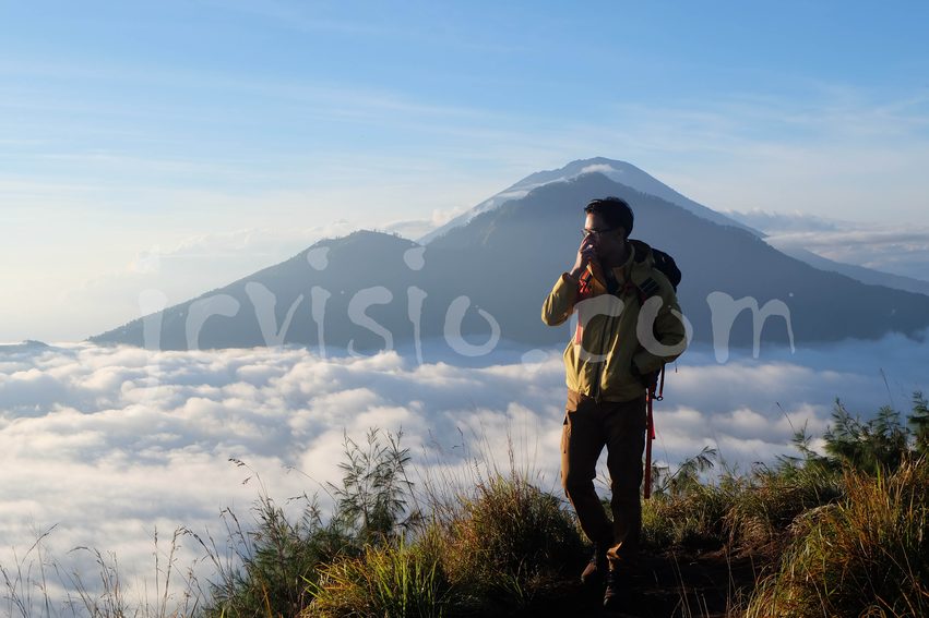 Hiker above the clouds at sunrise